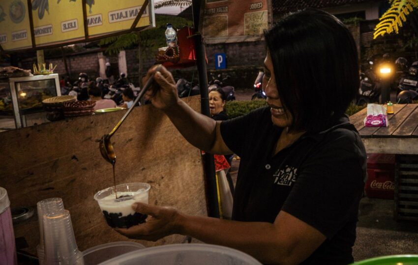 vendor dishing up black rice pudding